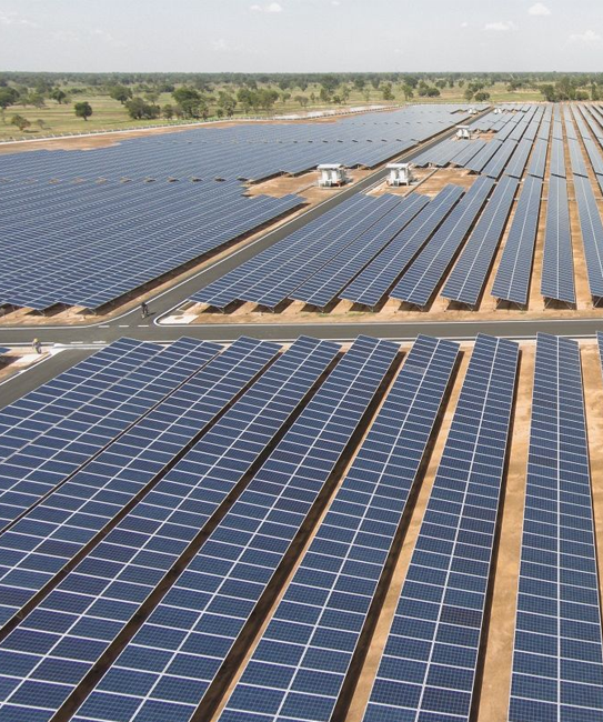 A vast solar farm with neatly arranged rows of solar panels, providing solar energy services.