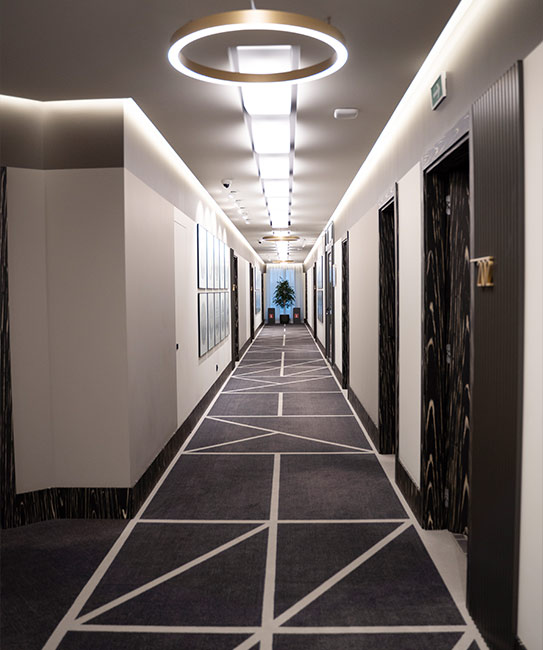 Office fit-out services displayed in a long hallway with a circular light above.